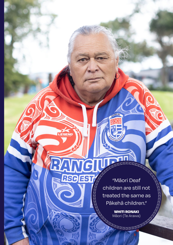 Whiti Ronaki standing outside in a park wearing a red, white and blue Rangiuru RSC hoodie