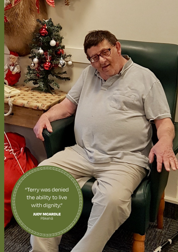 Terry Le Compte sitting in a dark green leather chair with a Christmas tree on a table behind him